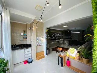 Sala de estar e cozinha com piso claro e paredes de azulejo em um imóvel no Brasil.