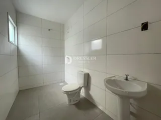 Foto de um banheiro com revestimento cerâmico branco.