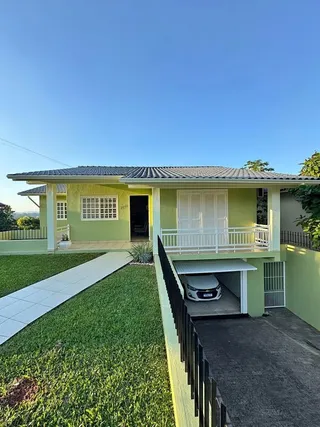 Fachada de uma casa com pintura verde e varanda em Lajeado, Brasil.