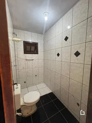 Foto de um banheiro com revestimento cerâmico claro nas paredes.