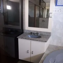 Vista de uma bancada com pia e armários em uma cozinha.