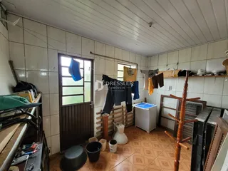 Interior de uma sala com piso de cerâmica e paredes brancas.