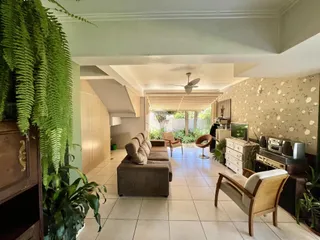 Sala de estar com piso de cerâmica e decoração verde.