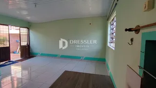 Ambiente interno de uma sala com piso de cerâmica e paredes verdes.