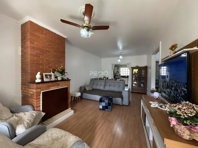 Sala de estar com parede de tijolos aparentes e piso de madeira.