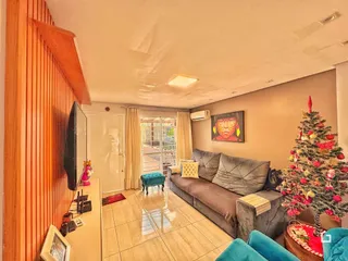 Sala de estar com sofá e árvore de Natal decorando o ambiente.
