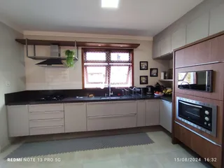 Cozinha moderna com armários e bancadas escuras.