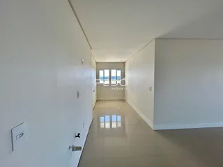 Corredor interno de uma residência com paredes brancas e piso claro.