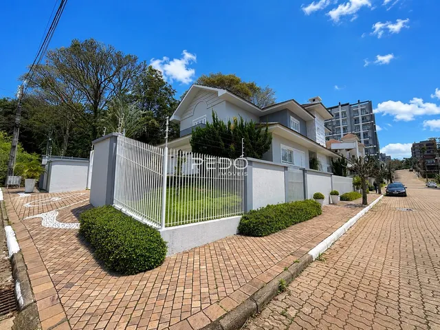 Fachada de uma residência em Lajeado, Brasil, com cerca e jardim.