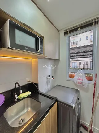 Foto da cozinha com armários e janela em Lajeado.
