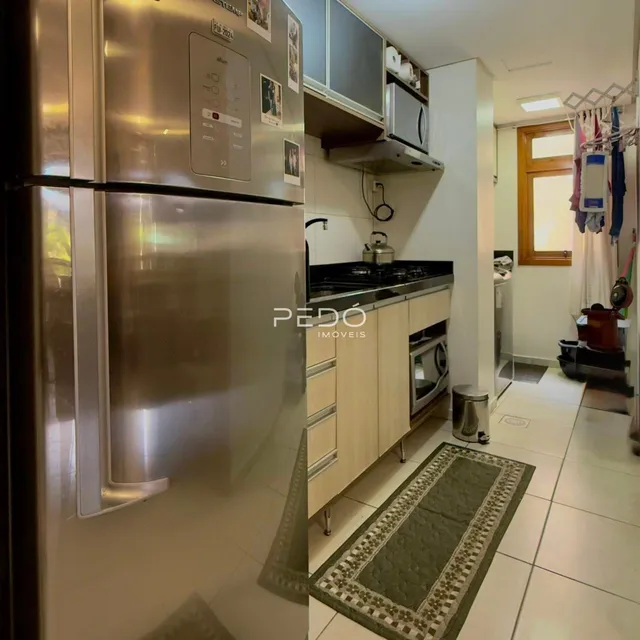 Foto da cozinha com armários e eletrodomésticos de aço inoxidável.