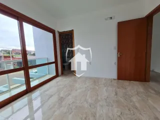 Sala de estar com piso de porcelanato claro e portas de vidro.