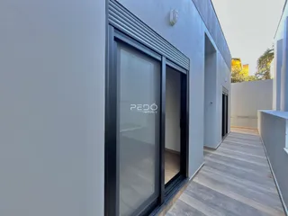 Fachada moderna de uma residência com porta de vidro e deck de madeira.