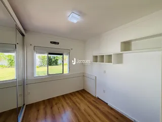 Ambiente interno com piso de madeira e paredes brancas.