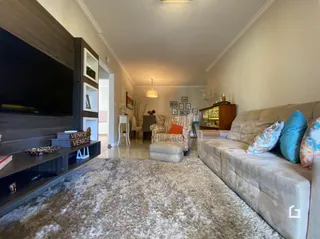 Sala de estar com sofá e televisão em um imóvel no Brasil.
