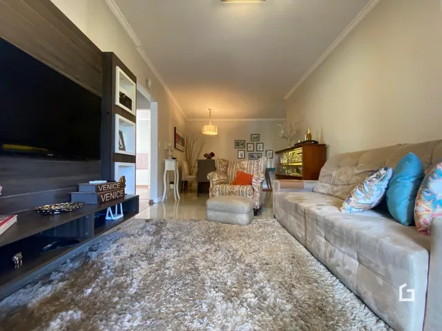 Sala de estar com sofá e televisão em um imóvel no Brasil.