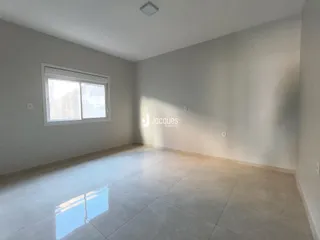 Ambiente interno de uma sala com piso de cerâmica e janela.