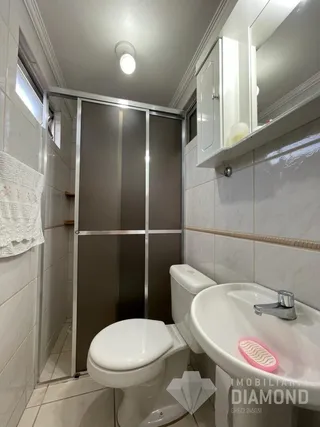 Foto de um banheiro com azulejos brancos e box de vidro.