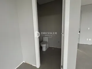 Hall com porta aberta mostrando um banheiro.