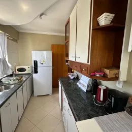 Foto de uma cozinha com armários de madeira e bancada escura.