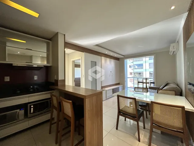 Ambiente moderno de sala de jantar e cozinha em um apartamento no Brasil.