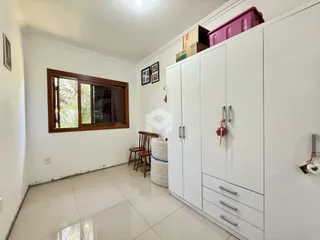 Hall de uma residência em Lajeado, Brasil com paredes brancas e piso de cerâmica.