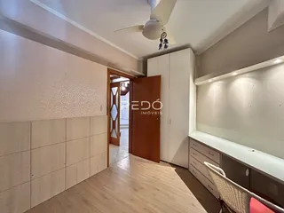 Hall de entrada com piso de madeira clara e armários embutidos.