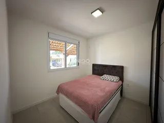 Quarto com cama e janela em ambiente claro.