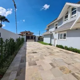 Área externa pavimentada com lajes claras em uma propriedade em Lajeado.