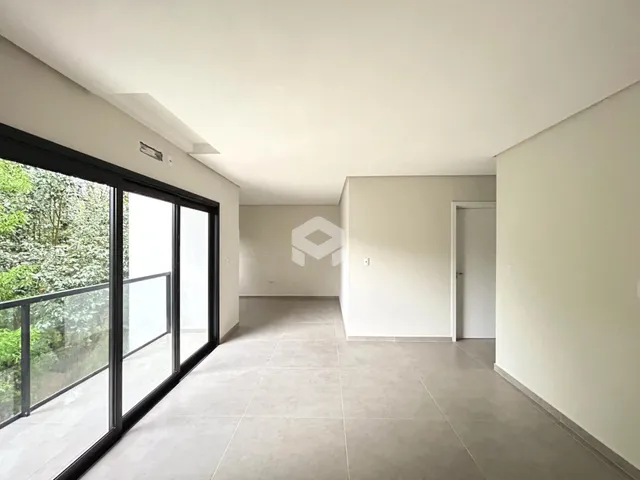 Vista interna de um ambiente com grandes portas de vidro e piso de cerâmica.