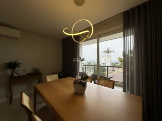 Ambiente interno de uma sala de jantar com vista para o exterior.