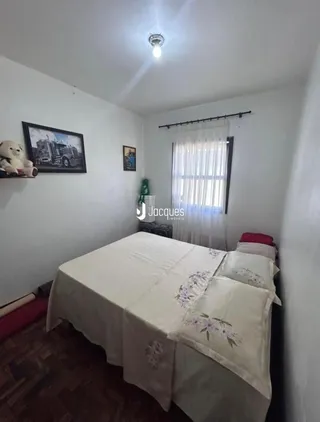 Quarto com cama e janela em uma residência.