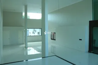 Interior de um espaço amplo com paredes brancas e piso claro.