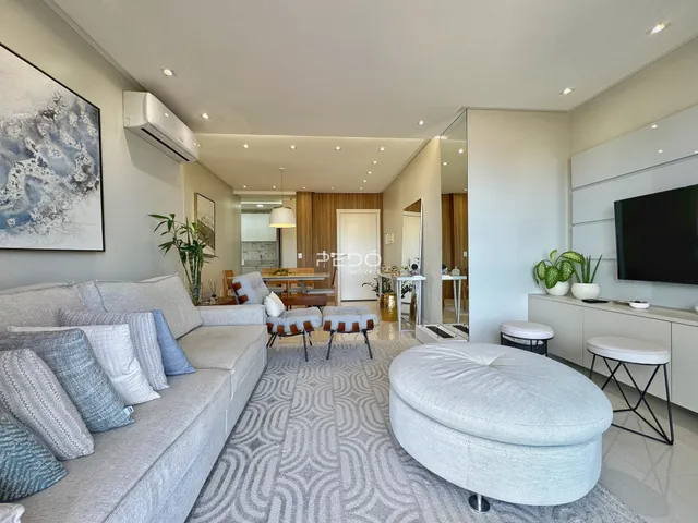 Sala de estar moderna com sofá e decoração clara.