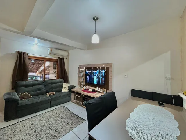 Sala de estar com sofá e televisão em um imóvel no Brasil.