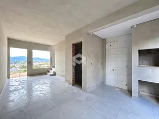 Interior de uma sala ampla com janelas que dão vista para a paisagem.