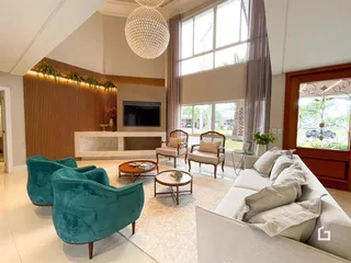 Sala de estar moderna com grandes janelas e decoração clara.