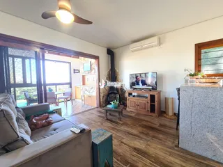 Sala de estar com piso de madeira e lareira em um imóvel no Brasil.
