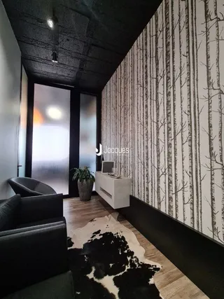 Interior de uma sala com parede de papel de parede listrado e piso de madeira.