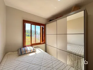 Quarto com janela de madeira e armário embutido.