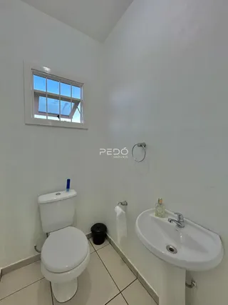 Foto de um banheiro com piso cerâmico e janela.