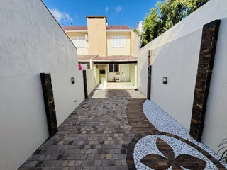 Vista da entrada de uma propriedade com pátio pavimentado.