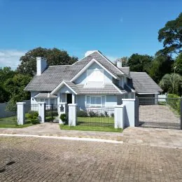 Fachada de uma casa residencial em Lajeado, Brasil, com telhado de telhas e muro de proteção.