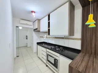 Cozinha moderna com armários brancos e bancada escura.