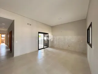 Vista interna de um ambiente amplo com paredes brancas e piso claro.