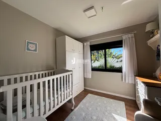 Quarto com cama e armários brancos em ambiente claro.