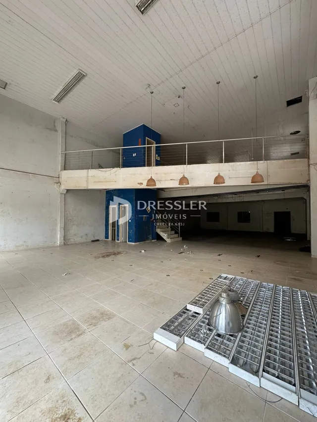 Imagem de um espaço interno com teto alto e estrutura exposta.