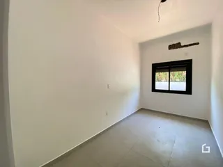 Ambiente interno de uma sala com paredes brancas e piso de cerâmica.