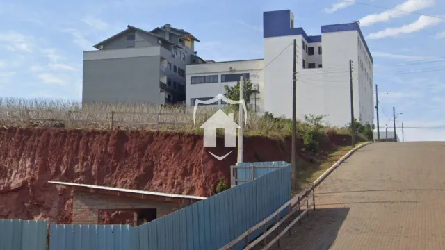Vista da fachada de um complexo residencial em Lajeado, Brasil, com um terreno inclinado.