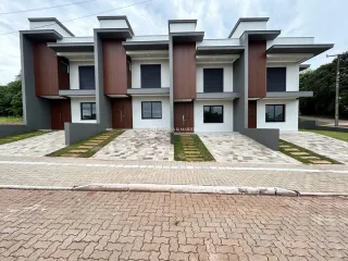 Fachada moderna de uma casa em Lajeado, Brasil, com revestimento em tons de marrom e cinza.